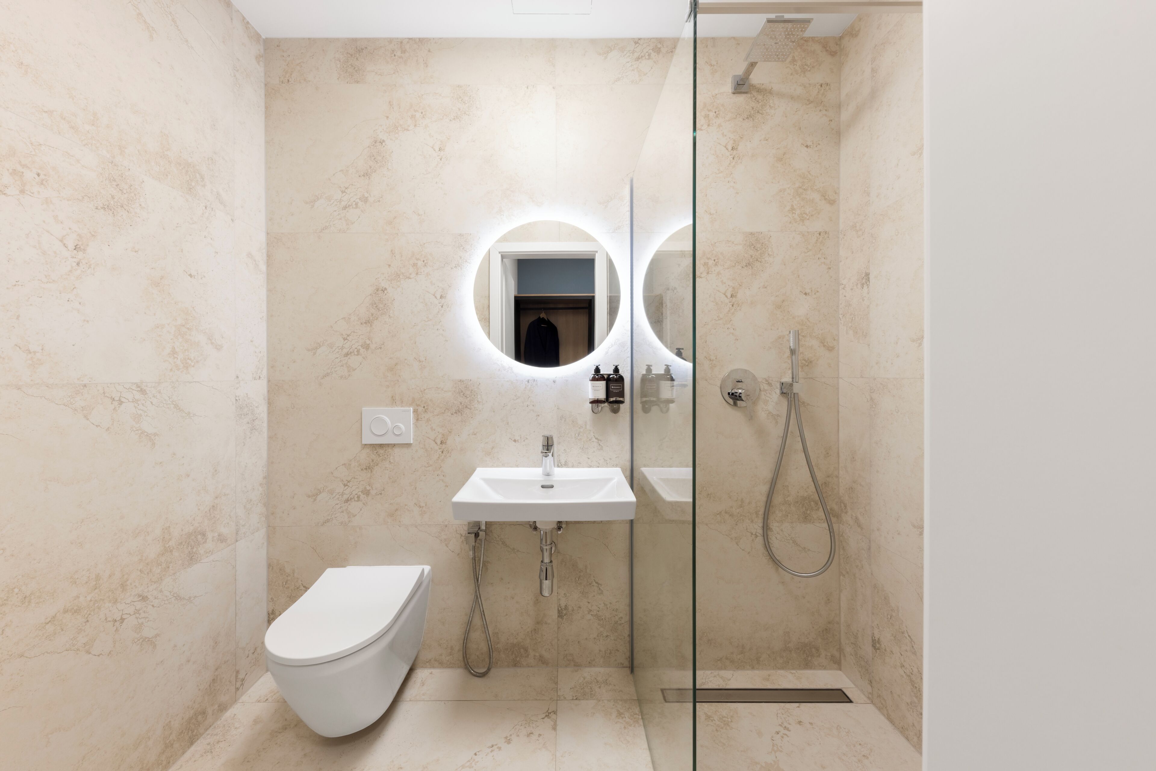 A modern bathroom with a toilet, a sink, and a shower.