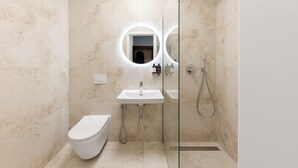 A modern bathroom with a toilet, a sink, and a shower. - Youngmann House (Prague)