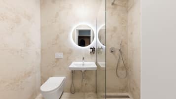 A modern bathroom with a toilet, a sink, and a shower.