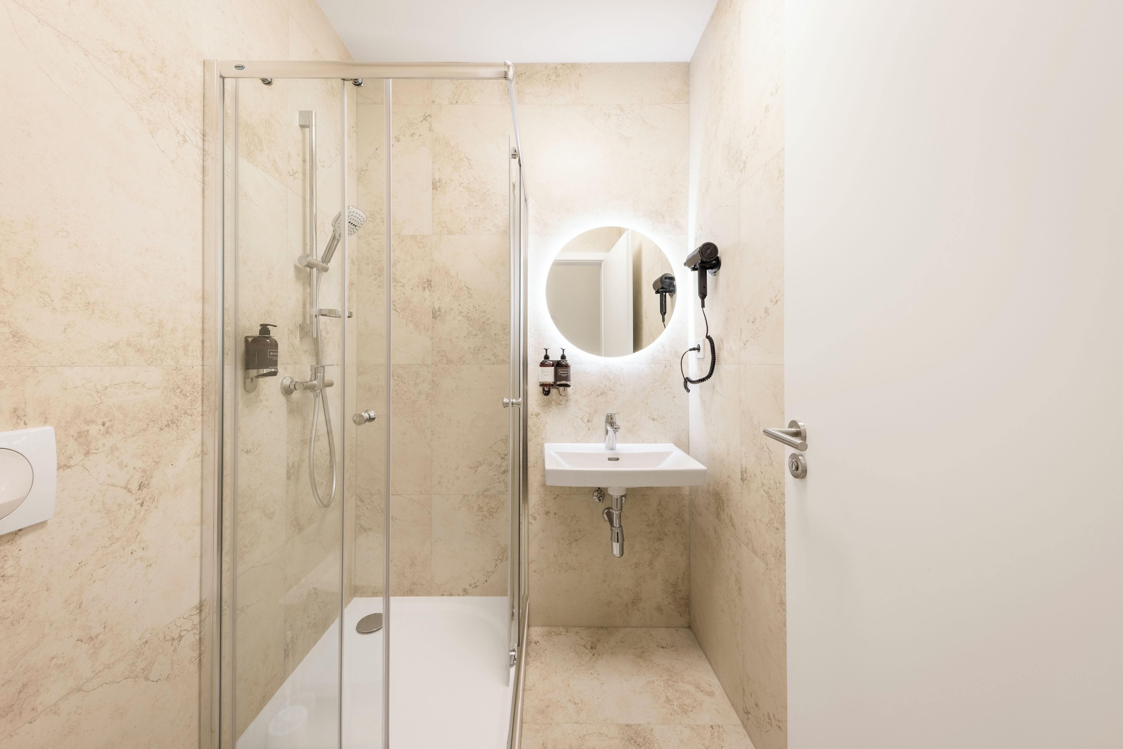 Une salle de bain avec une douche à parois de verre, un lavabo et un miroir.