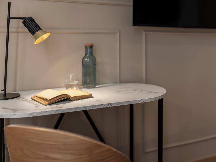 A marble-topped table with a book, a glass, and a bottle.