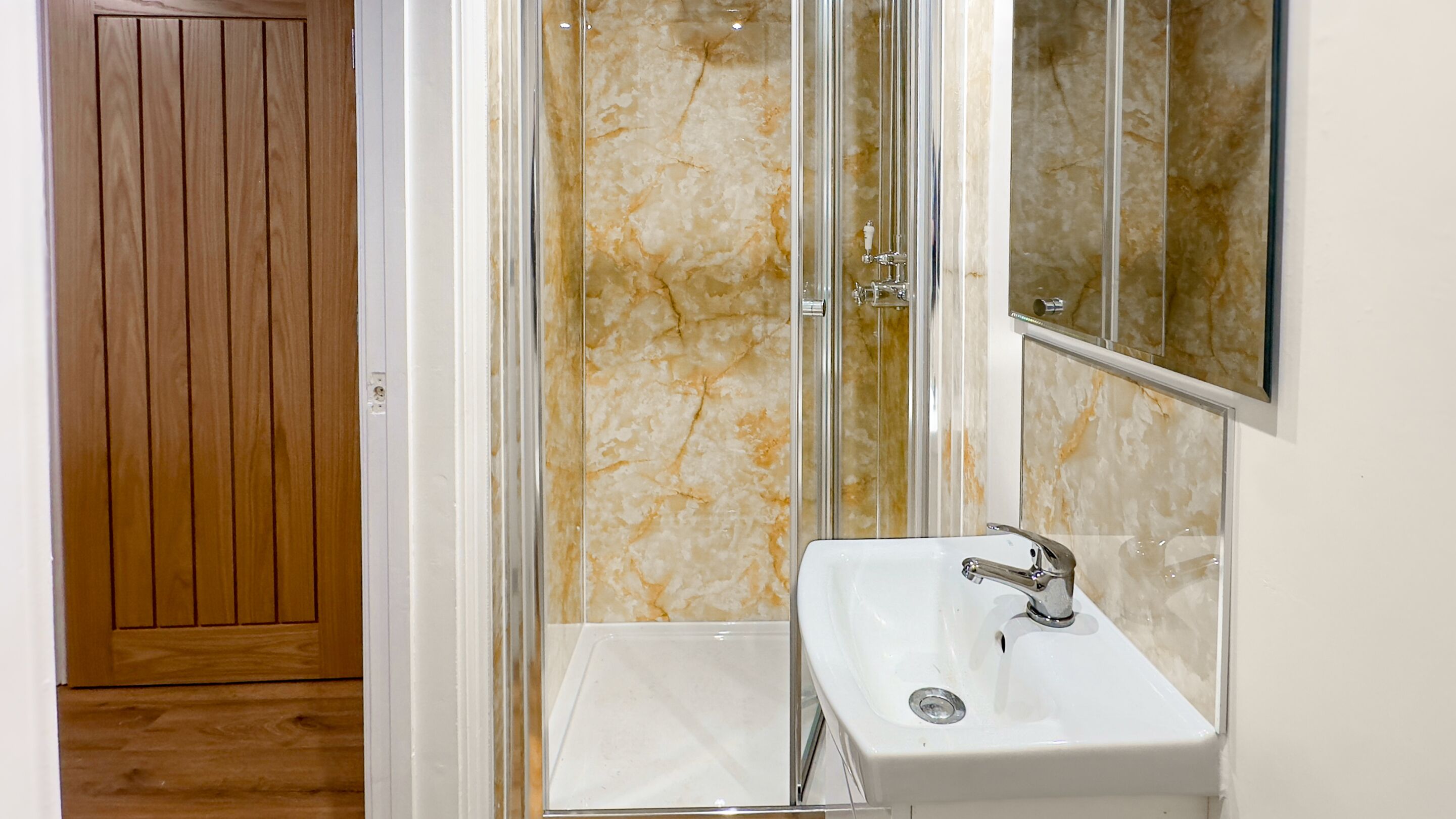 Un baño con ducha, lavabo y espejo.