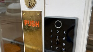 Μια πόρτα με μια χάλκινη πλάκα για να την ανοίγει κανείς και ένα πληκτρολόγιο με αριθμητικά πλήκτρα για να την κλειδώνει.