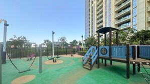 Ein Spielplatz mit Schaukeln, einer Wippe und einer Kletterkonstruktion.