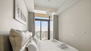 Ein modernes Hotelzimmer mit einem großen Bett, Blick auf die Stadt und einem minimalistischen Design.