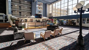 A spacious lobby with a patterned carpet, seating area, and a staircase leading to upper floors. - Oceanfront Carousel Condo • Beach Access Resort (Ocean City)