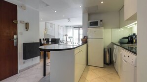Una cocina moderna con una isla central, electrodomésticos integrados y un comedor con sillas.