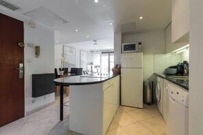 A modern kitchen with a central island, built-in appliances, and a dining area with chairs. - 3-bedroom apartment in awesome Cannes with cool AC breeze (Cannes)