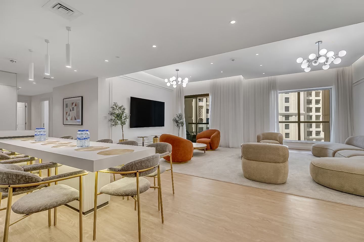 Un salón espacioso con una gran mesa de comedor, asientos cómodos y un televisor.