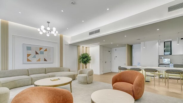 A modern living room with a sofa, armchairs, and a dining area with chairs and a table. - Sadaf 2701 (Dubai)