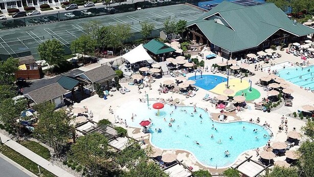 A resort with multiple swimming pools, sun loungers, and a covered pavilion.