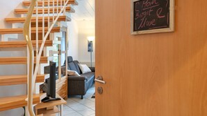 Eine hölzerne Treppe führt zu einem Raum, in dem ein Kreidetafel mit der Aufschrift 'Main Birgit & Mue' steht.
