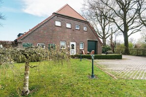 Un bâtiment en briques avec un toit en pente, une porte verte et une allée pavée.
