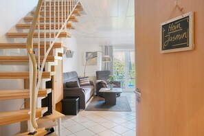 Ein modernes Wohnzimmer mit Treppe, Sofa, Couchtisch und einem Schild an der Wand.