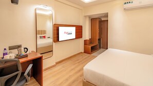 A hotel room with a bed, desk, chair, mirror, and a TV screen displaying 'PLAYSALS BY DEAN WRIGHT'. - Playsales SSR (Indore)