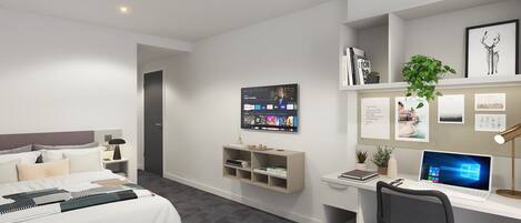 A modern hotel room with a bed, a desk with a laptop, a TV mounted on the wall, and a small plant.