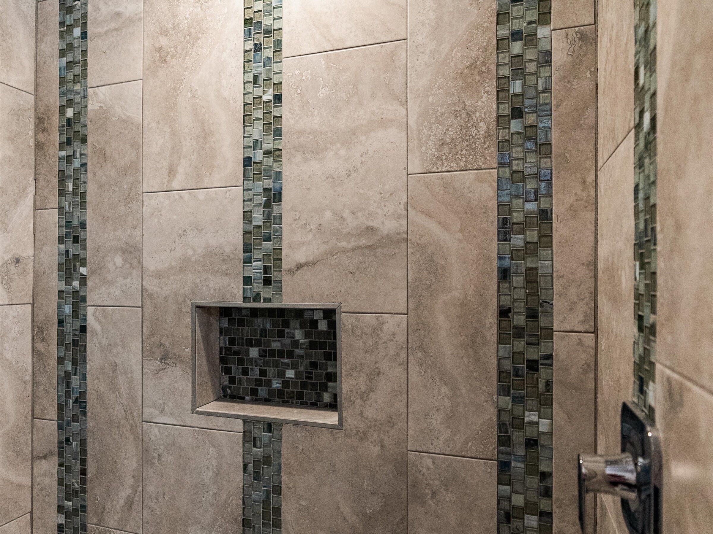 A tiled wall with a central square tile feature, surrounded by larger rectangular tiles.