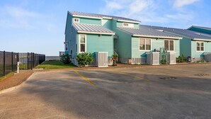 A row of two-story houses with a parking lot in front. - Pier Perfection K101 3 Bedroom Condo (Rockport)