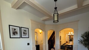 A spacious room with a large wooden table, a white sofa, and framed artwork on the wall. - Spacious 4-bedroom townhome in fantastic Bronzeville Chicago Neighborhood (Chicago)