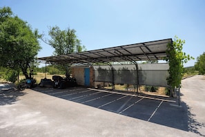 A covered parking area with a metal roof, a blue door, and a bicycle parked to the side. - Villa Peaceful Valley With Heated Pool (Sestanovac)