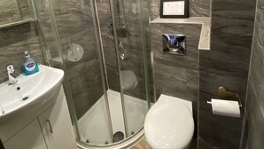 A modern bathroom with a glass-enclosed shower, a white sink, and a toilet. - Enjoyable 4-bed, 2.5 bath apartment in the heart of London - Hoxton Zone 1 (London)