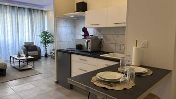 Una cocina moderna con comedor, un sofá y una planta.