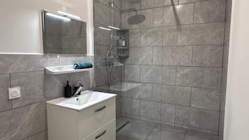 Regadera, toallas, shampoo, papel de baño