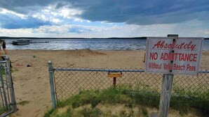 En strand med en skylt som säger: ”Absolut inget tillträde utan giltigt entrépass för Valley Beach.”
