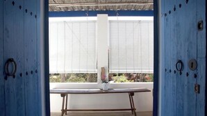 A room with a large window, a wooden table, and a white pillar. - Rural House Ca Ses Llussianes - ET/0641 (Sant Francesc de Formentera)