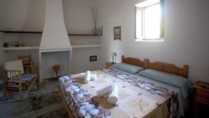 A bedroom with a bed, a chair, a window, and a fireplace. - Rural House Ca Ses Llussianes - ET/0641 (Sant Francesc de Formentera)
