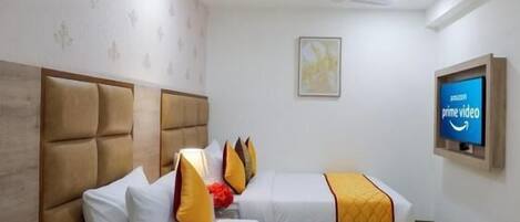 Une chambre d’hôtel avec deux lits, un ventilateur de plafond, une télévision et une table de chevet.