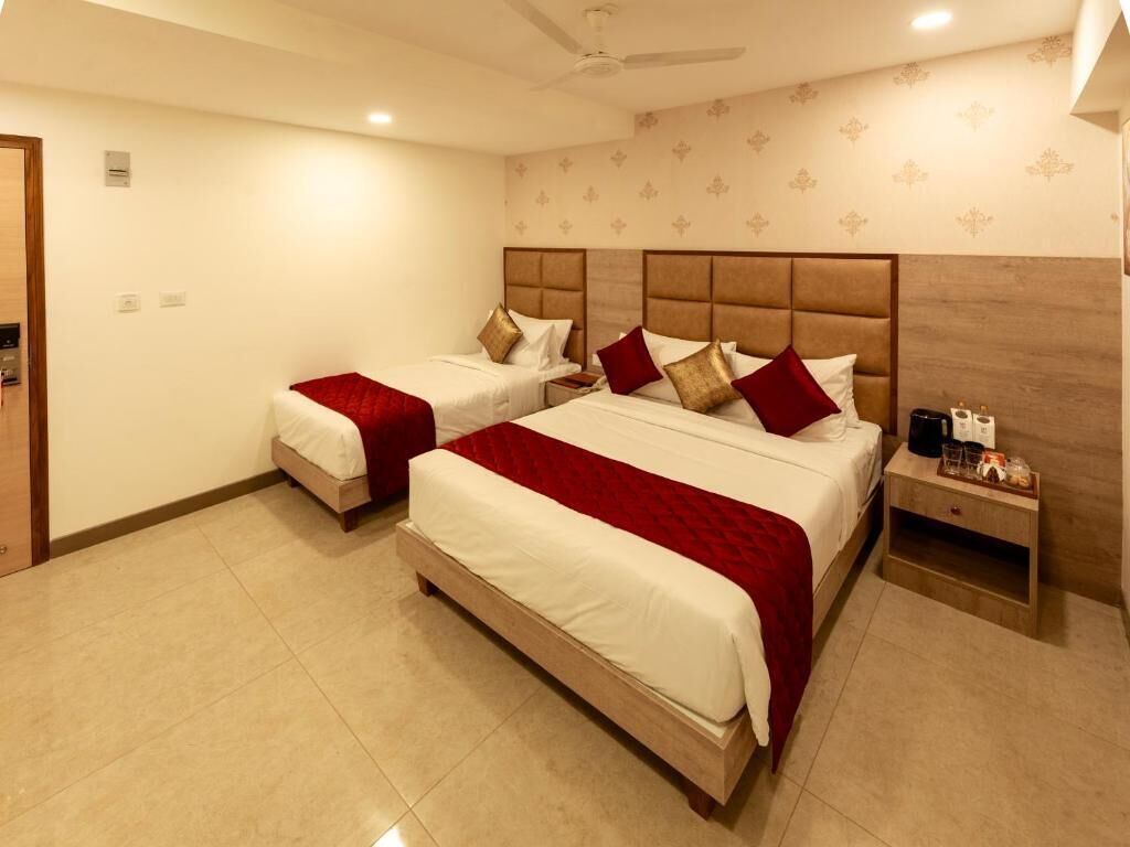 Une chambre d’hôtel avec deux lits, une table de chevet et un ventilateur de plafond.