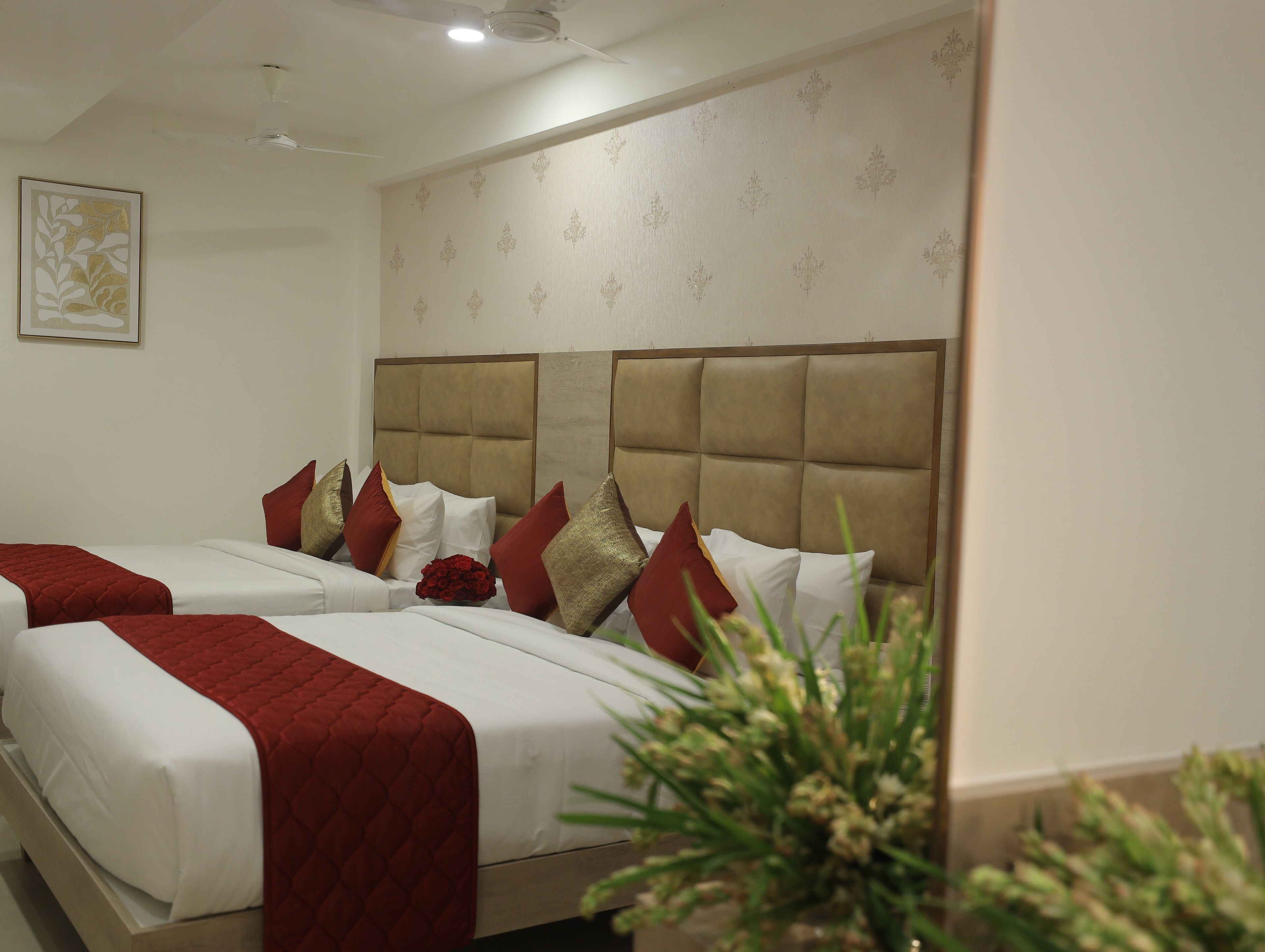 Habitación de hotel con dos camas, un cabecero grande y un muro decorativo.