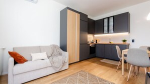 Un appartement moderne doté d’une kitchenette, d’un canapé et d’un coin repas.