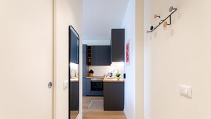 Une cuisine moderne avec des meubles de couleur sombre, un plan de travail en bois et un petit îlot central.