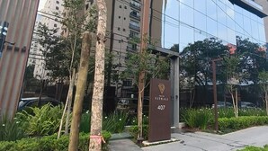 Un edificio moderno con facciata in vetro, un cartello con la scritta 'VITRAELI 407' e un ingresso con cancello.