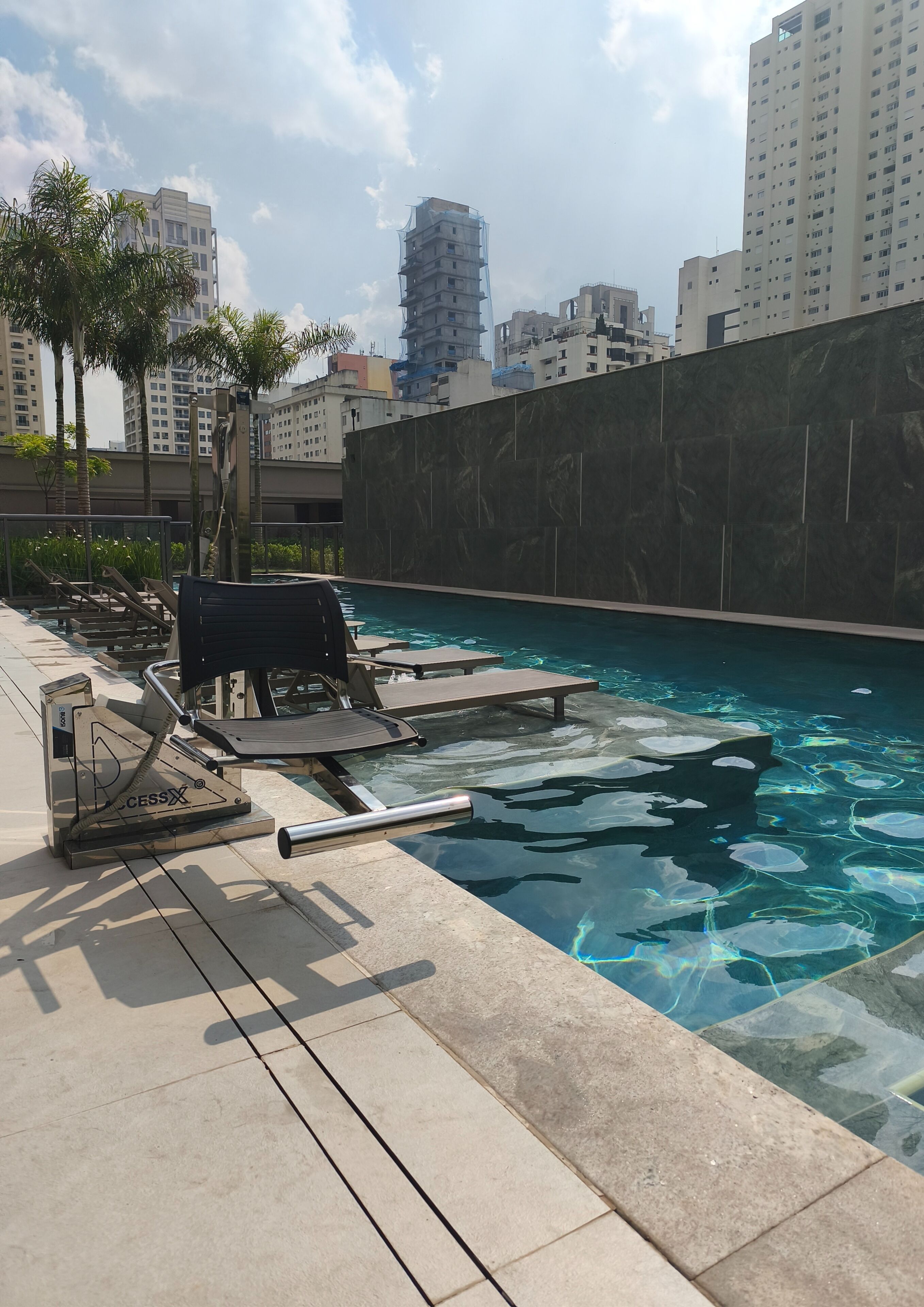 A swimming pool with lounge chairs and a water filtration system.