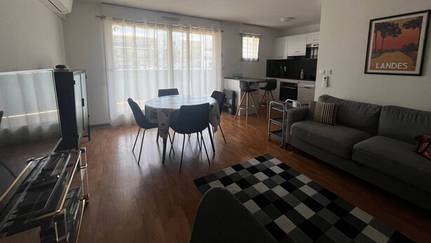 A compact living space with a dining area, kitchenette, and a sofa. - Apartment 'Les Balcons du Soleil' – Ideal for Spa Guests - Conciergerieland (Saint-Paul-lès-Dax)