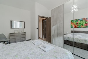 Ein modernes Schlafzimmer mit einem großen Bett, einer Kommode, einem Spiegel und einem einzigartigen Wandbild.