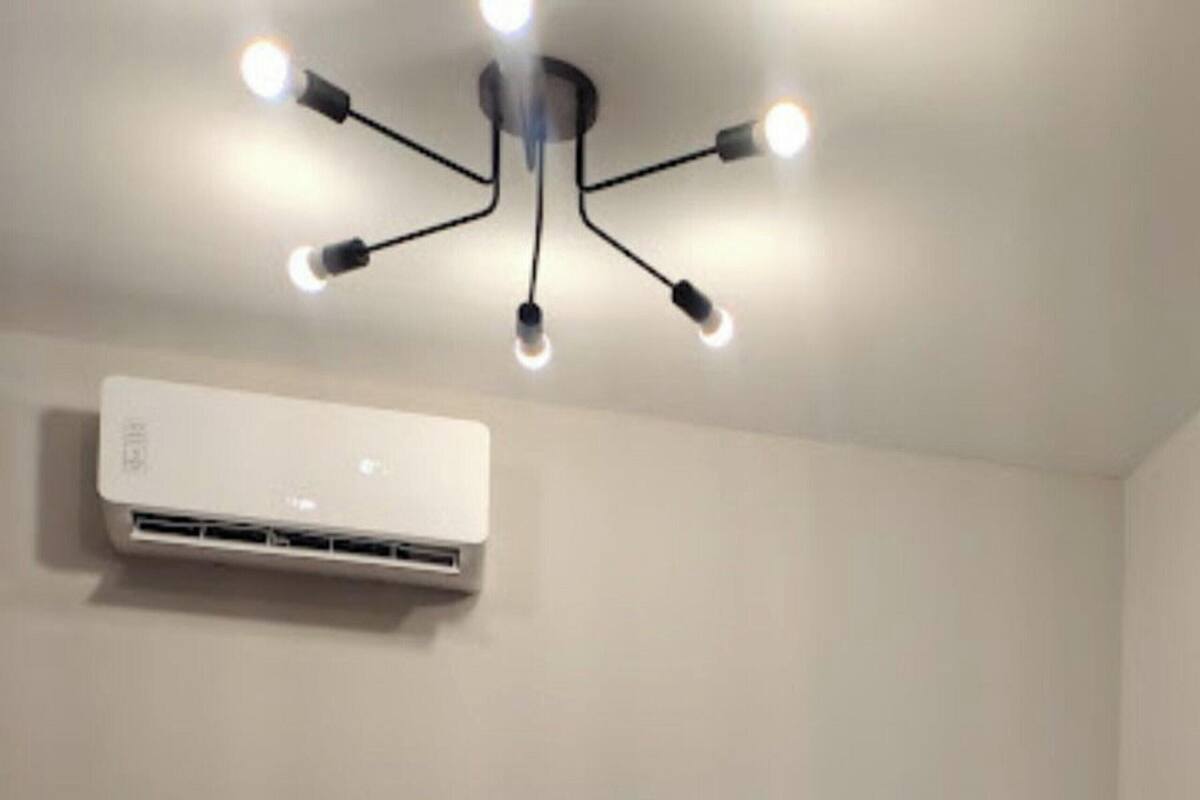 Una camera da letto con un letto, un lampadario a soffitto e un condizionatore d'aria.