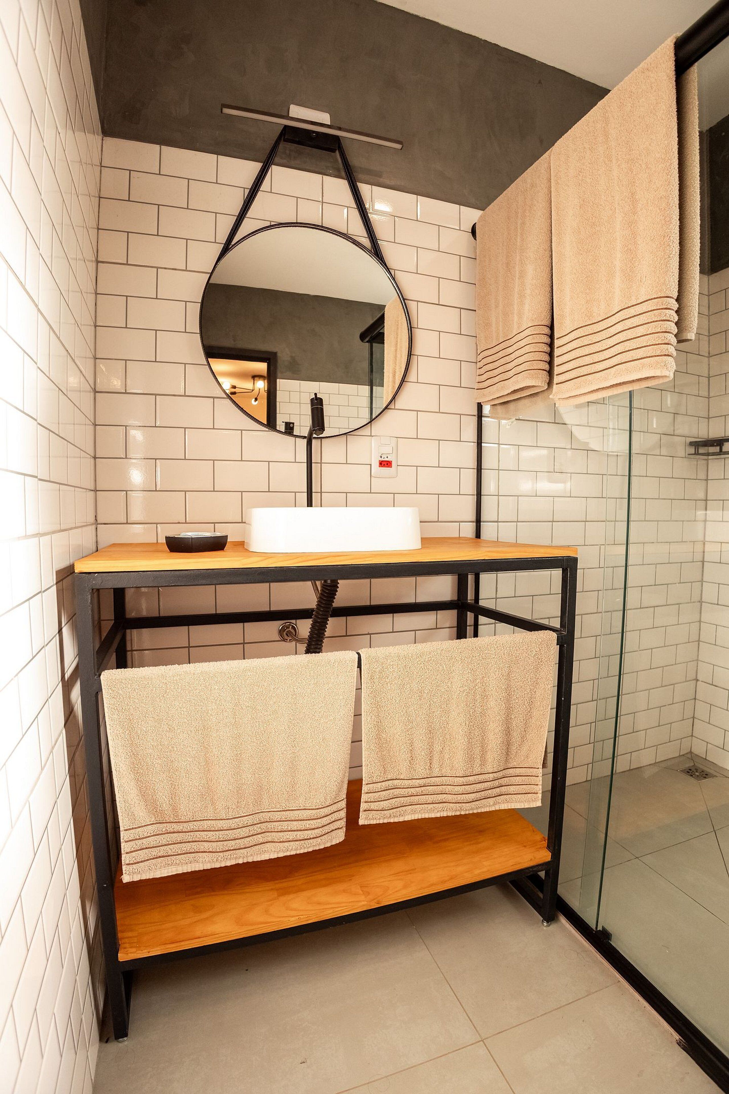 A bathroom with a white sink, a mirror, and two towels hanging on a rack.