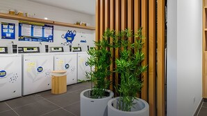 A modern hotel reception area with a wooden slat partition, a reception desk, and a wall-mounted information board. - Artline Barranco (Lima)