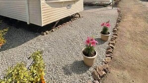 Una hilera de casas móviles con entrada de grava y plantas en macetas.