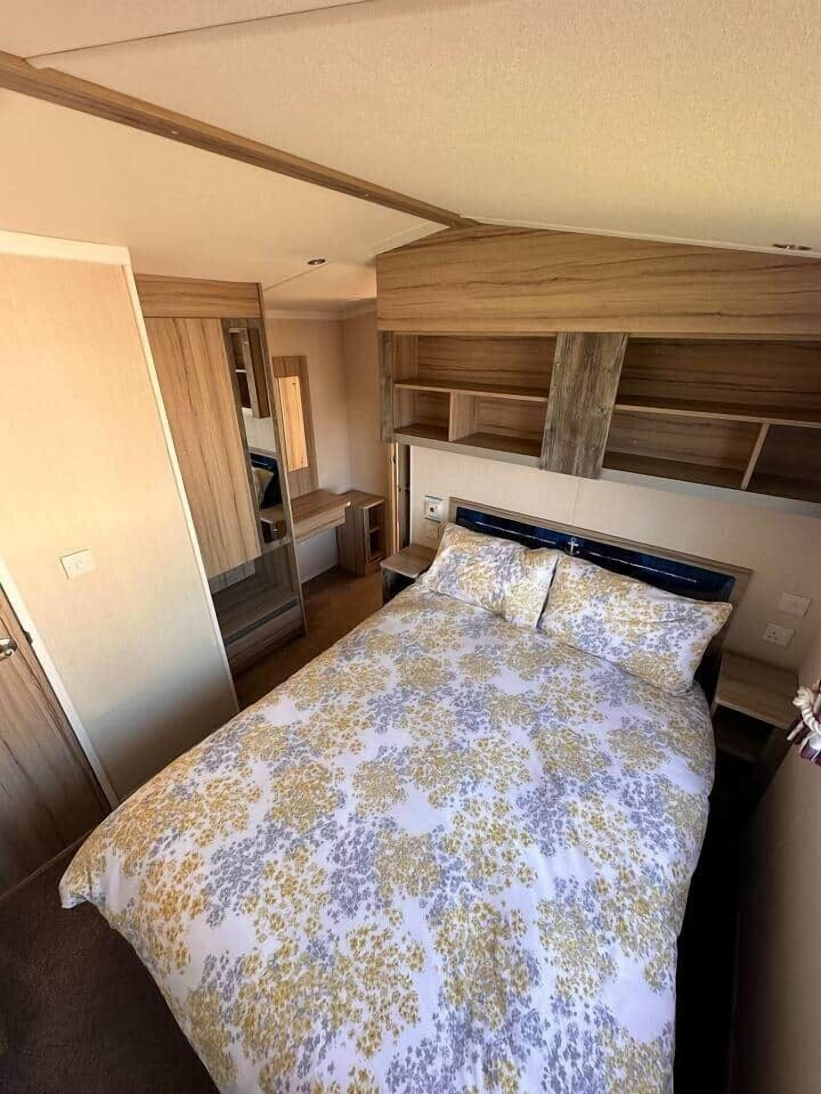 Een slaapkamer met een bed, een houten hoofdbord en een klein nachtkastje.