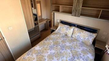 Een slaapkamer met een bed, een houten hoofdbord en een klein nachtkastje.