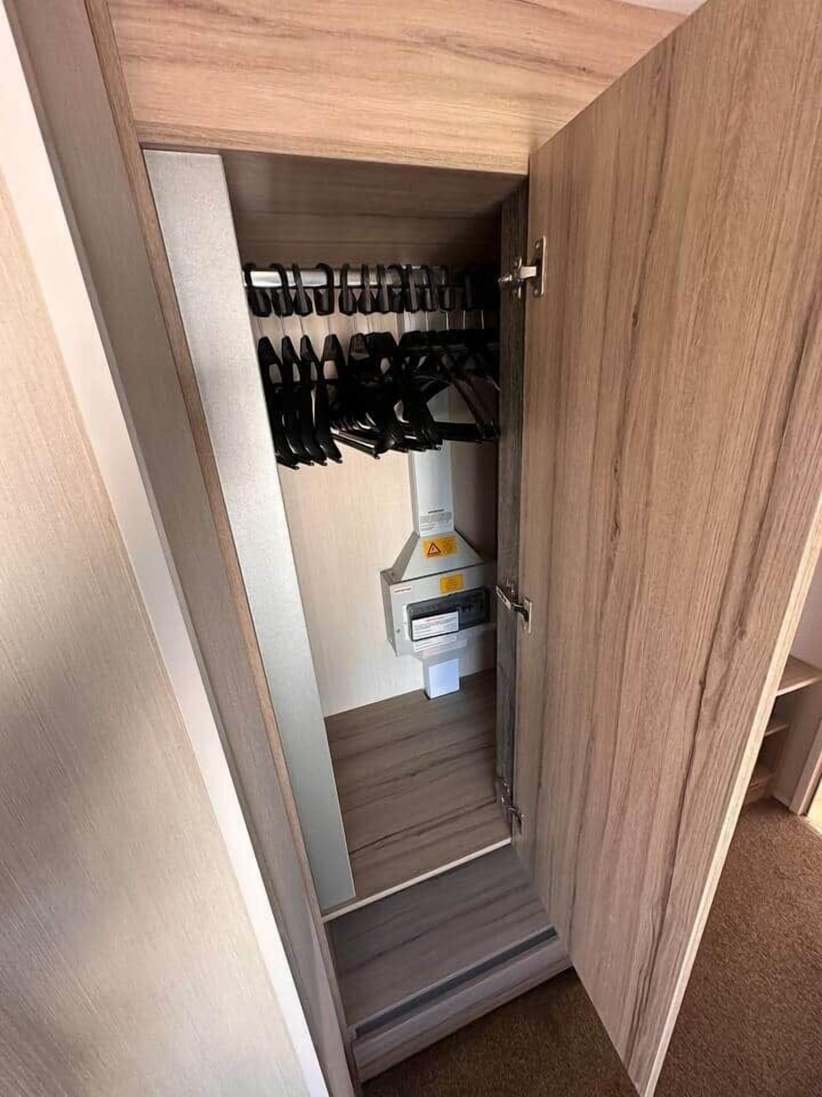 Ein Holzschrank mit Schuhablage und einem kleinen weißen Schrank.