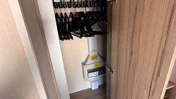 Ein Holzschrank mit Schuhablage und einem kleinen weißen Schrank.