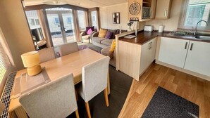Un espace de vie compact comprenant un coin repas, une kitchenette et un coin salon.