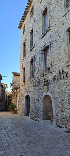 A stone building with arched windows and a sign that reads 'Hotel de Ville.' - Apartment in the heart of the medieval village with a view of the sea   (Tourrettes-sur-Loup)