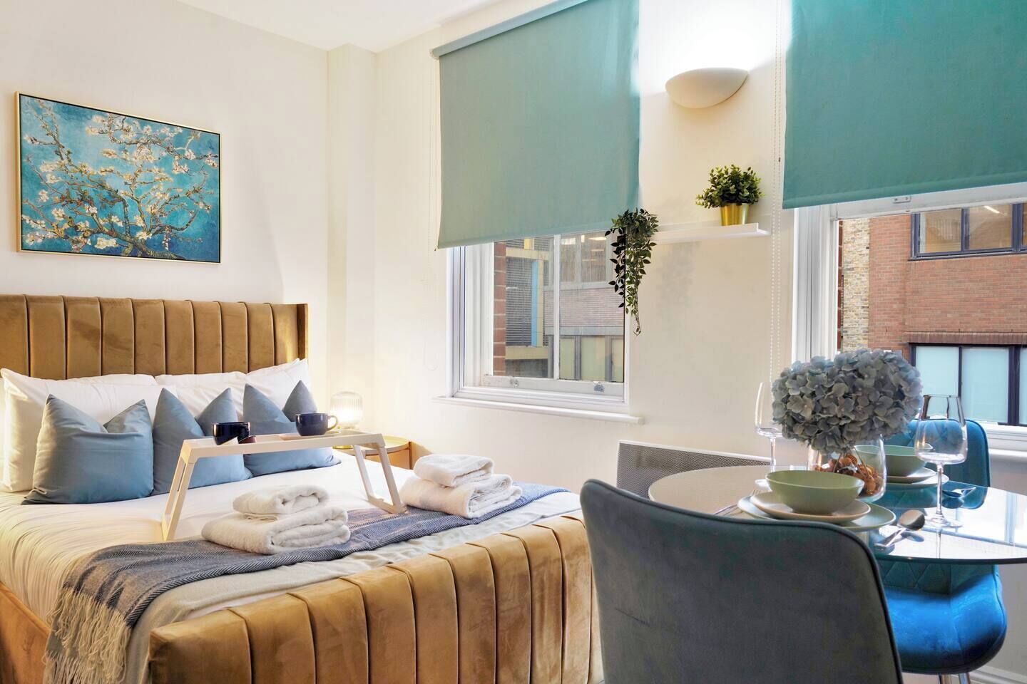 Une chambre d’hôtel comprenant un lit, une table de chevet et un coin repas avec une table et des chaises.